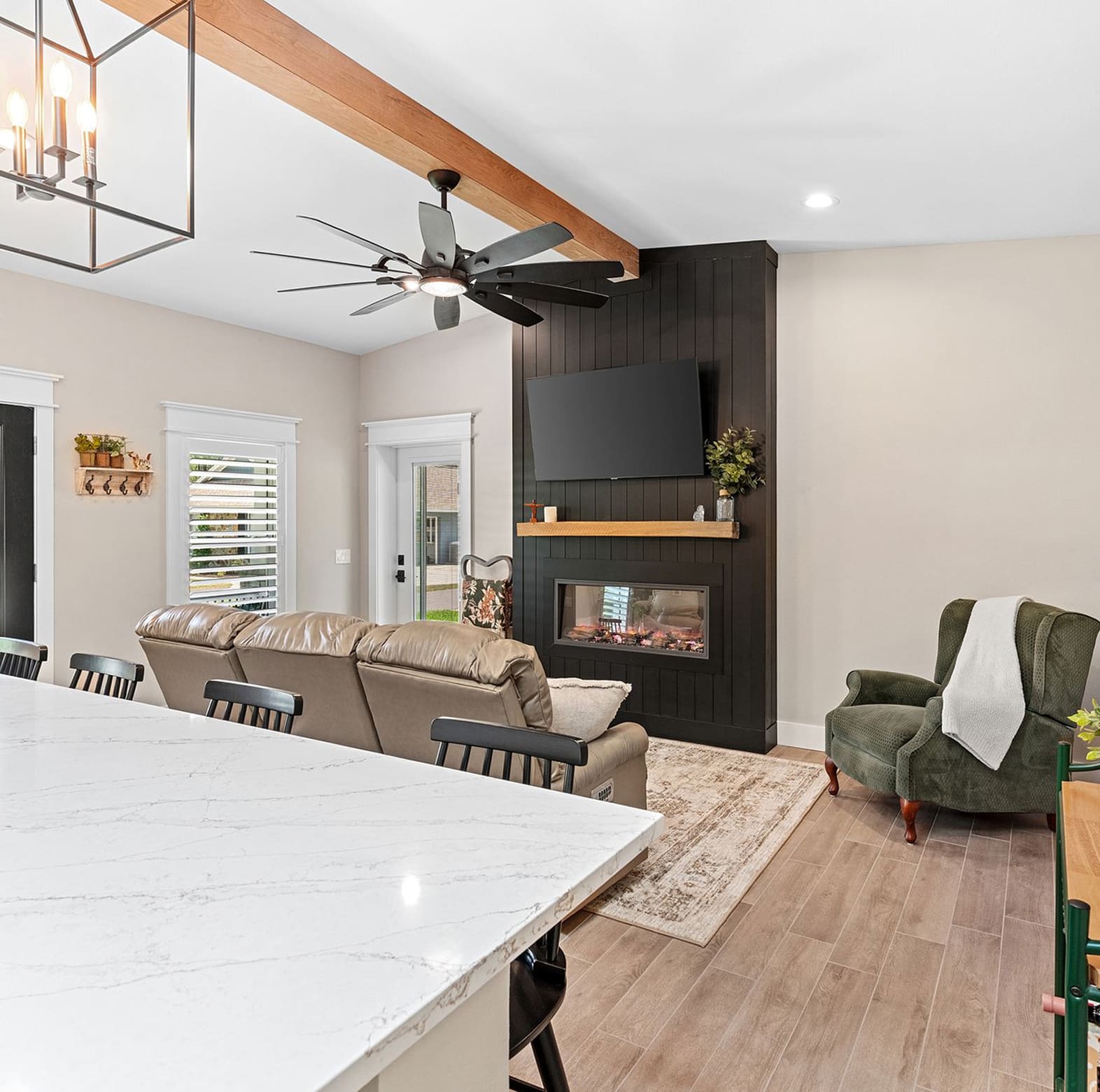 Modern living room with black fireplace wall and kitchen island